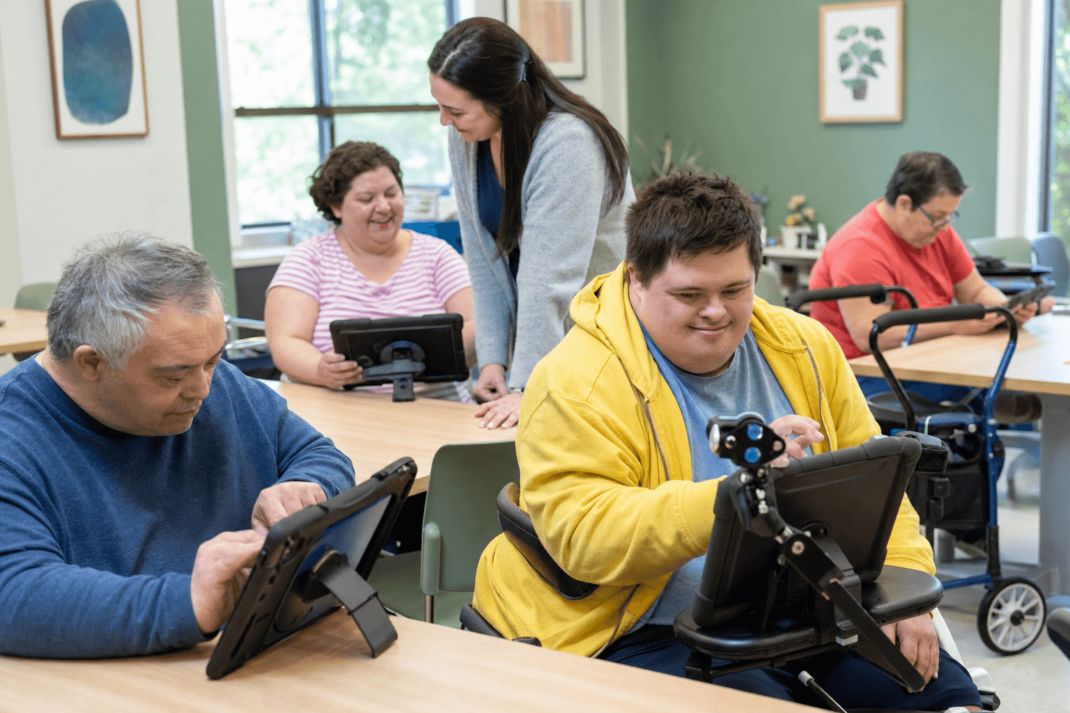 Adults with developmental disabilities using accessible technology together at a Franklin Park day program